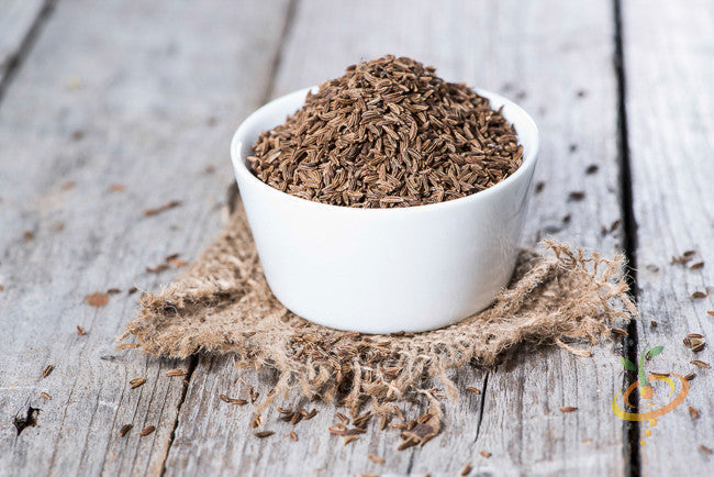 Close-up of fresh Caraway seeds from SeedsNow, showing small brown seeds with ridged texture on a white background.